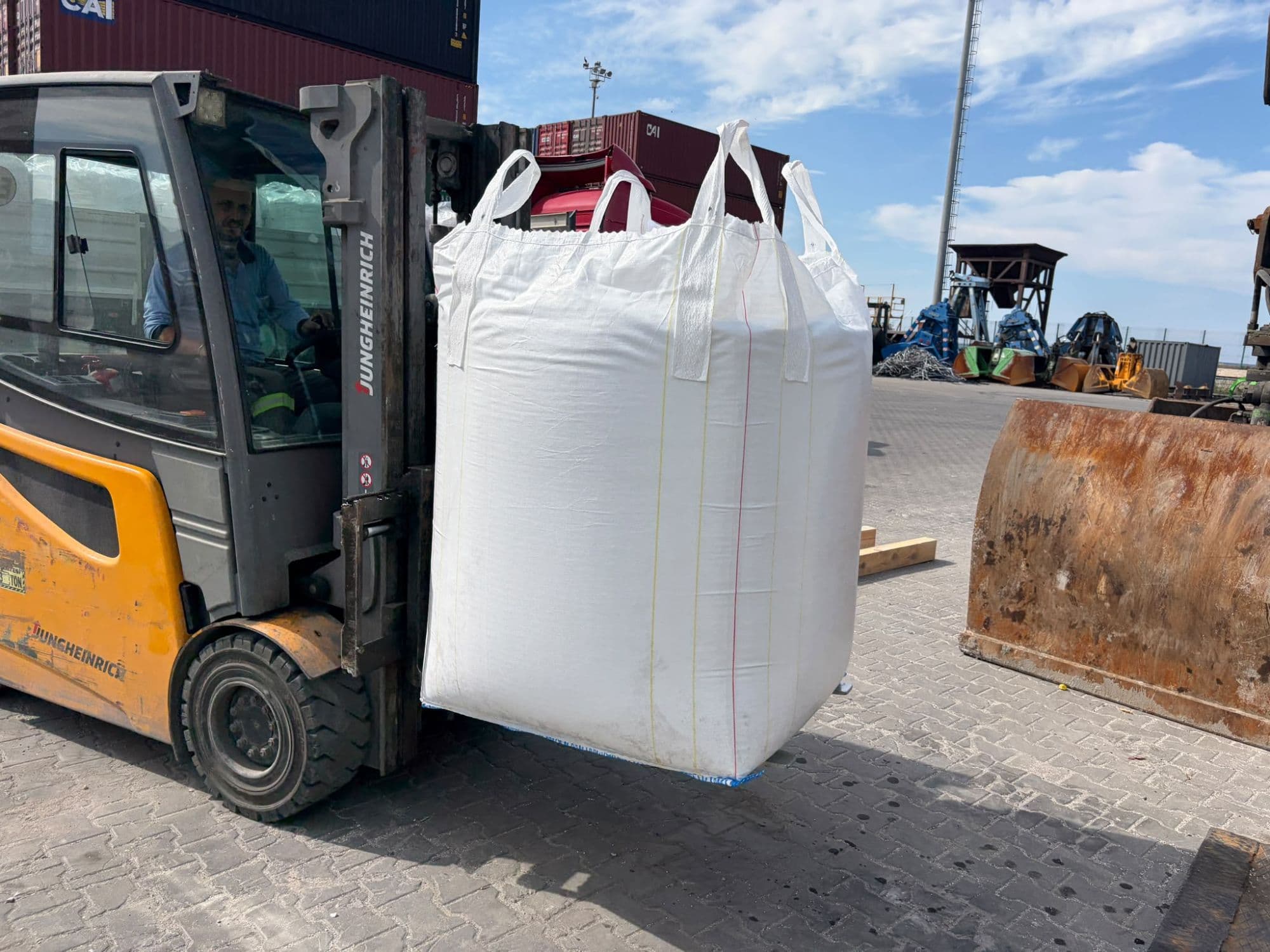 A big bag being moved by forklift. The bag body, lifting loops and base are checked for tears or leakage.